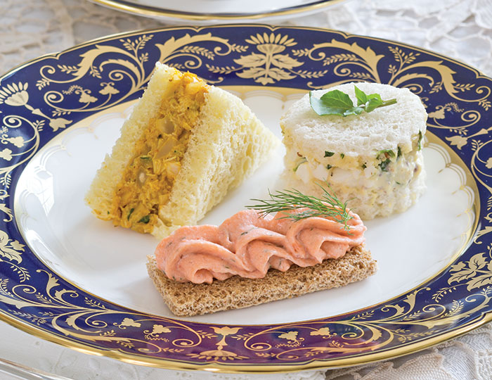 Clockwise, from upper left, Coronation Chicken Salad, Watercress and Egg Salad Tea Sandiches, and Dilled Salmon Mousse Canapés from our Fit for a Queen Tea.